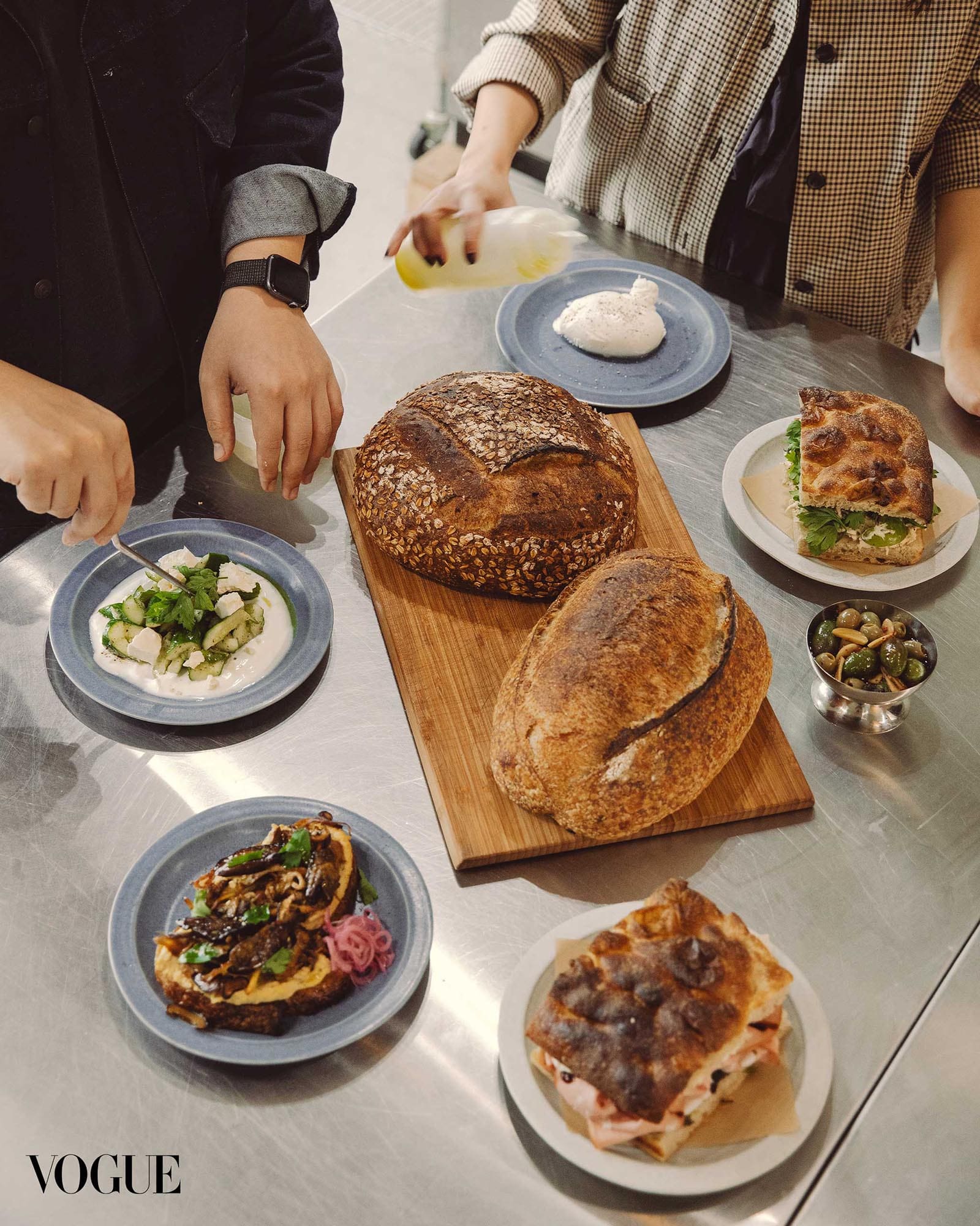 A spread of artisan bread, sandwiches, and plated dishes at the Ani Cafe counter
