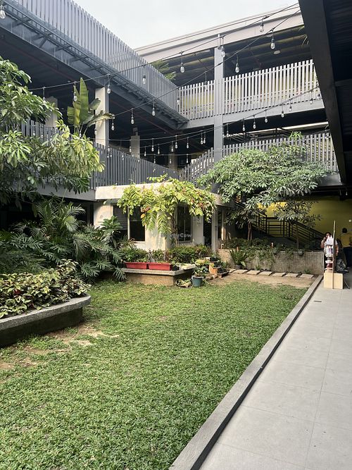 The garden courtyard at Comuna where Ani Cafe is located, featuring lush greenery and string lights