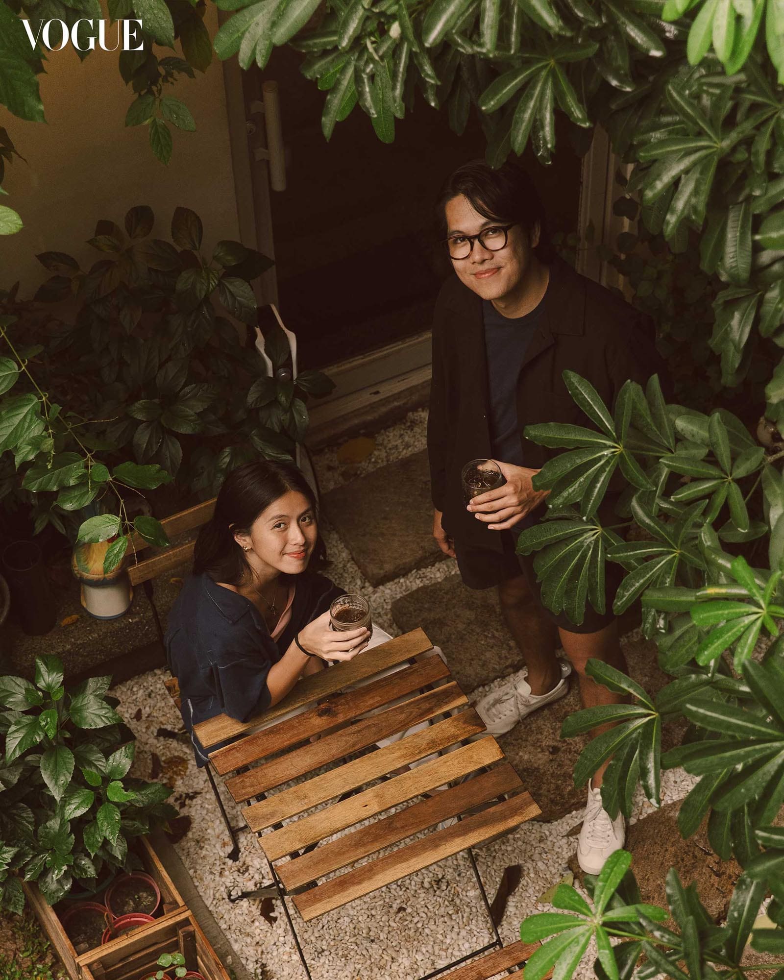 Garden seating area at Ani Cafe surrounded by tropical plants, two people enjoying coffee